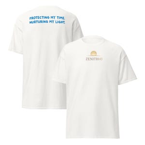 Puede incluir: Dos camisetas blancas. Una camiseta tiene el texto azul "PROTECTING MY TIME. NURTURING MY LIGHT." en la espalda. La otra camiseta tiene un gráfico de sol dorado y el texto dorado "ZENITH40" en la parte delantera.