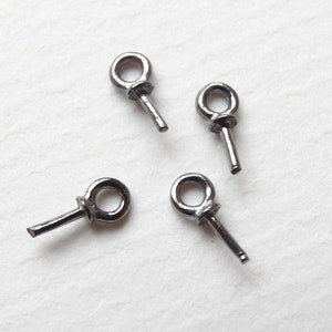 May include: Four silver jump rings with a 2 mm diameter. Each ring has a straight pin attached to the bottom.