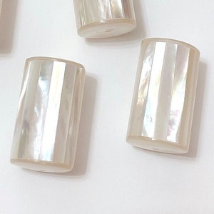 以下が含まれることがあります： 真珠のような光沢のある白いストライプ模様の円筒形のビーズが4つあります