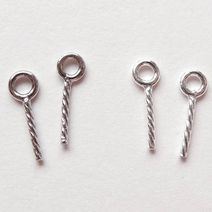 May include: Four silver jump rings with twisted wire stems. The jump rings are about 1/2 inch long.