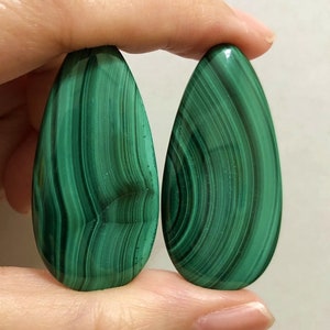 Pode incluir: Par de cabochões de malaquita verde em forma de lágrima. Par A.