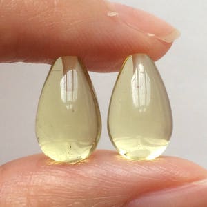 Può includere: Due perline di vetro giallo traslucido a forma di lacrima.