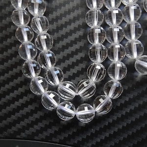 以下が含まれることがあります： 透明なファセットカットのクリスタルビーズのストランド。ビーズは丸く、滑らかで磨かれた仕上げになっています。ビーズは透明な糸に糸で通されています。