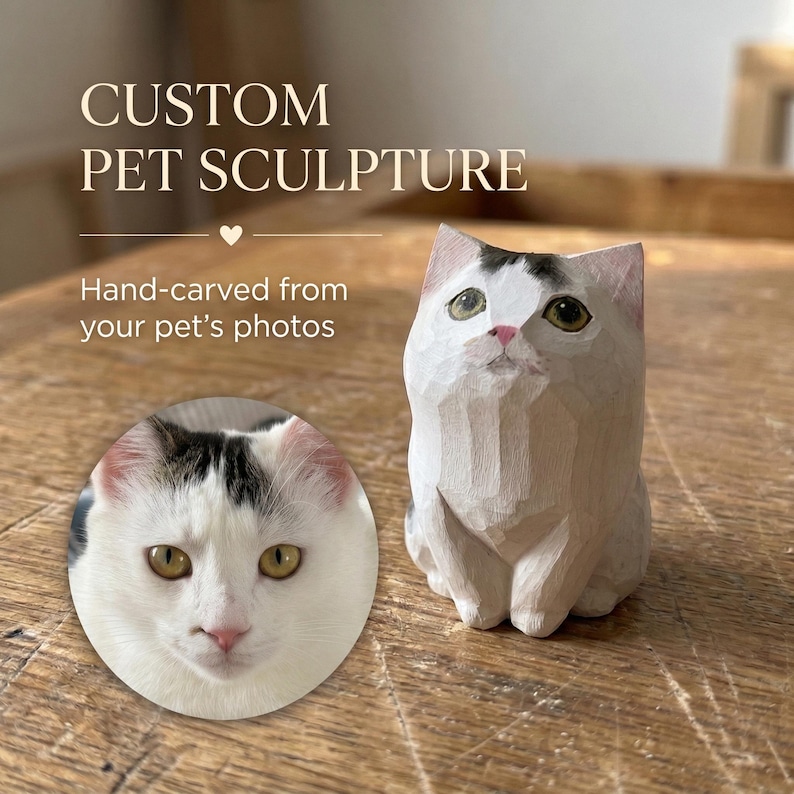 May include: A hand-carved wooden cat sculpture featuring a white coat with dark patches on the head, pointed ears, and painted eyes. The sculpture is displayed alongside a circular inset photograph of a white cat with dark head markings.