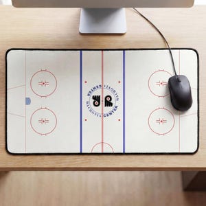 Könnte beinhalten: Eine rechteckige Schreibtischunterlage mit einer Grafik eines weißen Eishockeyfeldes, roten Anspielkreisen, blauen Linien und einem zentralen Logo mit der Aufschrift Wachovia Center sowie dem Emblem der Philadelphia Flyers.
