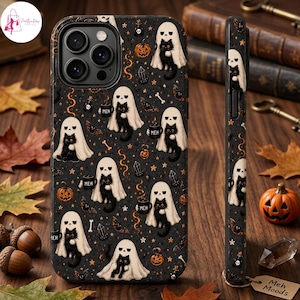 May include: A black phone case featuring a repeating pattern of black cats wearing white ghost sheets, holding mugs labelled "MEH," surrounded by orange pumpkins, bats, bones, and crystals. The design covers the back and side of the phone case.