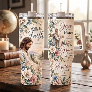 May include: Two stainless steel tumblers with straws and handles, featuring floral designs and religious text. One shows a figure in robes with the text Walk by Faith 2 Corinthians 5:7. The other shows a cross with Jesus is my Peace John 14:27, Grace Upon Grace John 1:16, and He restores my soul Psalm 23:3.