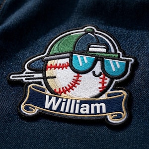 May include: Embroidered baseball patch featuring a baseball wearing sunglasses and a baseball cap. The patch has the name "William" on a blue banner. The baseball is white with red stitching, and the cap is green and navy.