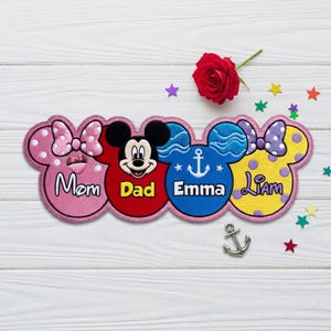 May include: A custom embroidered patch featuring four connected Mickey Mouse-shaped silhouettes. The first is pink with a bow and the text Mom, the second is red with the text Dad, the third is blue with an anchor and Emma, and the fourth is yellow with a purple bow and Liam.