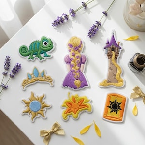 May include: A collection of seven embroidered patches featuring a green chameleon, a gold tiara with blue gems, a sun emblem, a person with a long blonde braided hair in a purple dress, a tall stone tower, a yellow flower, and an orange lantern.