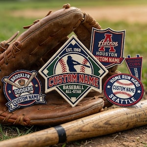 Puede incluir: Una colección de parches de béisbol con texto personalizable, con logotipos de equipos y diseños temáticos de béisbol. Los parches tienen varias formas, incluyendo un escudo, una bandera y un diseño circular. Un guante y un bate de béisbol están en el fondo.