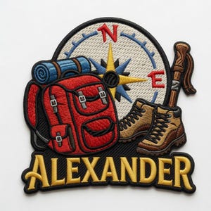 Puede incluir: Parche bordado con una mochila roja, botas de montaña, una brújula y un bastón de senderismo. El parche incluye el nombre "ALEXANDER" en letras doradas. Un saco de dormir enrollado azul y negro está encima de la mochila. La rosa de los vientos apunta al norte y al este.