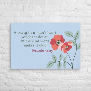 May include: A canvas print with a light blue background features the text "Anxiety in a man's heart weighs it down, but a kind word makes it glad. -Proverbs 12:25." Two red and orange flowers with green leaves are on the right.