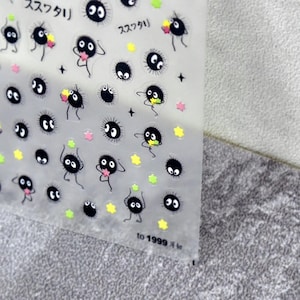 May include: Clear sheet of stickers featuring black, round characters with large eyes and small arms. Some characters hold stars or have yellow and green accents. Japanese text is at the top. The text "to 1999" is at the bottom.