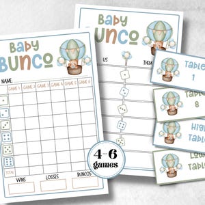 May include: Baby Bunco game set with a hot air balloon theme. The set includes score sheets, table cards, and a dice chart. The colour scheme is soft blue, green, and brown. The text on the set reads "Baby Bunco" and "4-6 games".
