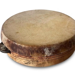 Könnte beinhalten: Ein rundes Tamburin mit einem Naturfell. Der Holzrahmen ist hellbraun mit dunkleren braunen Akzenten. Eine einzelne Metallschelle ist sichtbar. Das Instrument ist für die Perkussion bestimmt, mit einem Durchmesser von ca. 20 cm.