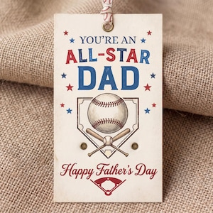 May include: A rectangular off-white gift tag with a baseball-themed design. It features the text "YOU'RE AN ALL-STAR DAD" in red and blue, a baseball illustration over home plate with crossed bats, and the text "Happy Father's Day" in red script.