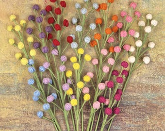May include: A collection of decorative floral stems featuring small, round, felt-like spheres in a variety of colors including yellow, purple, red, light blue, white, orange, and pink, all attached to thin, green, wire-like stems.