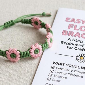 May include: A handmade macrame bracelet featuring pink daisy flowers and green cord. The bracelet is next to a guide titled "Easy Daisy Flower Bracelet" for crafters aged 10 and up. The guide lists the materials needed to make the bracelet.