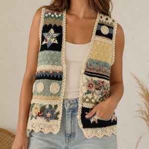 Pode incluir: Um colete de malha sem mangas com um design de patchwork apresentando várias texturas e padrões em tons de creme, preto, amarelo, azul e verde. A peça inclui motivos florais, detalhes em crochê circular e uma borda festonada na cor creme.