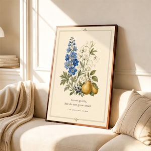 May include: A framed wall art print featuring a botanical illustration of blue delphinium flowers, white sweet peas, and two yellow pears. The text reads: Grow gently, but do not grow small. - AN ORIGINAL VERSE. The print has a cream background.