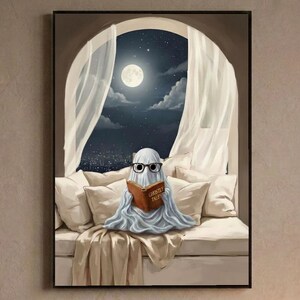 Painterly print of a small ghost in round glasses reading in bed by a moonlit window, holding a book titled Ghostly Tales, framed above a bed with linen bedding and a lit candle on the nightstand