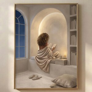 Woman reading in a quiet arched nook, neutral wall art print in a thin gold frame on a warm beige wall, soft plaster arch, draped linen, and candlelight, no mat.