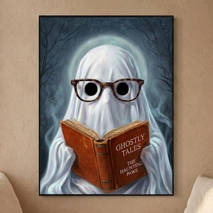 The ghost reading print hanging above a cushioned window bench with a wool throw and a small pumpkin on the sill