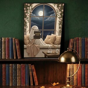 The window seat coffee ghost reading print framed and leaning on a dark wood library shelf against a deep green wall