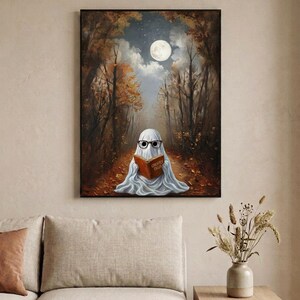The autumn forest ghost reading print framed in a calm neutral living room above a linen sofa