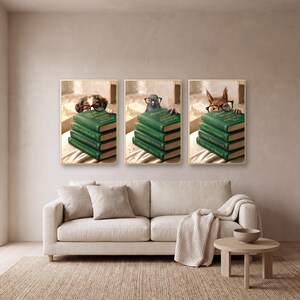 Three framed animals peeking over books prints on a plaster wall above a cream linen sofa with a knitted throw and a small round oak table.