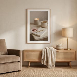 Evening journal ritual wall art printable above cane console with velvet armchair and fiddle leaf fig, neutral beige home office corner