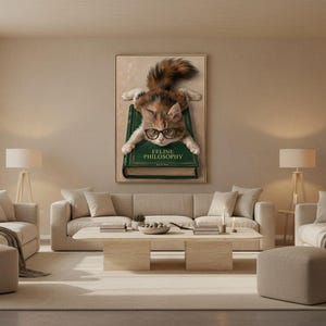Wide view of a neutral living room with the kitten on book print framed above a low sofa in soft daylight