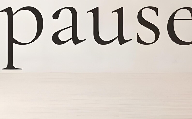 Close-up detail from You Are Allowed to Pause, a cropped fragment of the printable artwork: the word ‘pause’ set in a fine serif, the letters running past both edges of the frame, above a pale wood floor.