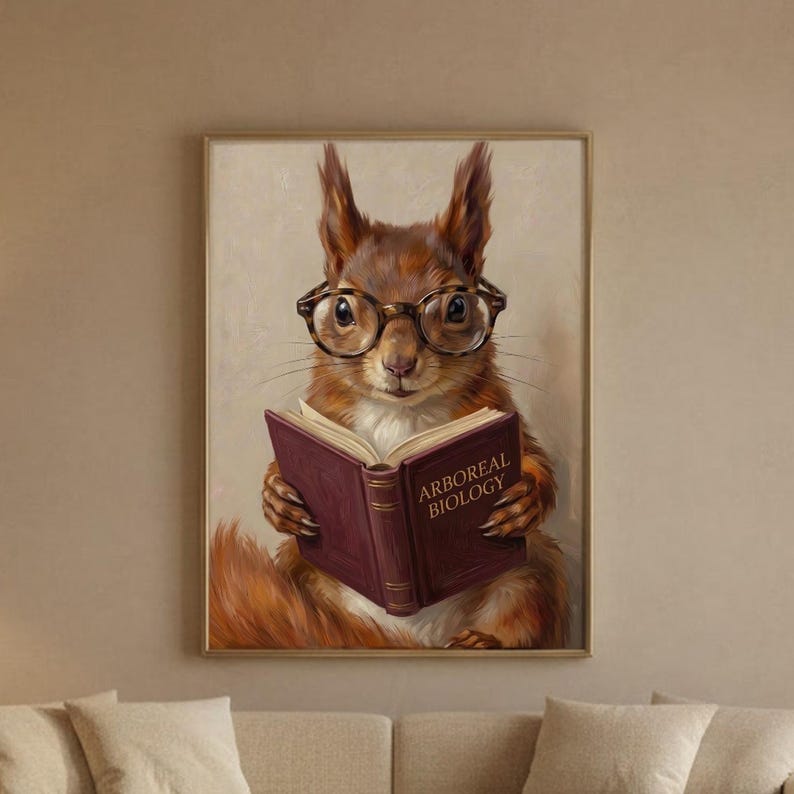 Painterly print of a red squirrel in round tortoiseshell glasses reading a wine-red book framed in a slim wood frame on a warm plaster living-room wall above a cream linen sofa