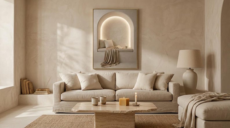 Wide living room view showing the reading nook wall art centered above a low sofa, gold frame, no mat.