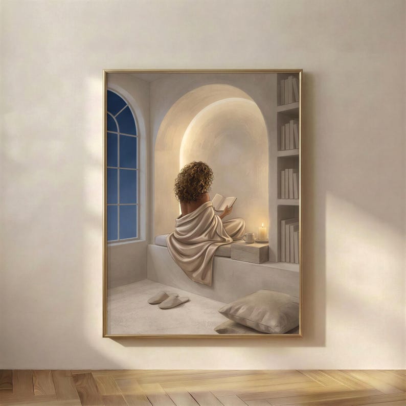 Woman reading in a quiet arched nook, neutral wall art print in a thin gold frame on a warm beige wall, soft plaster arch, draped linen, and candlelight, no mat.