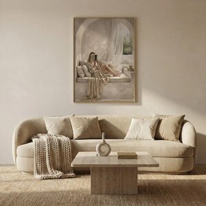 Wide living room view showing the woman reading nook wall art centered above a low sofa, gold frame, no mat.
