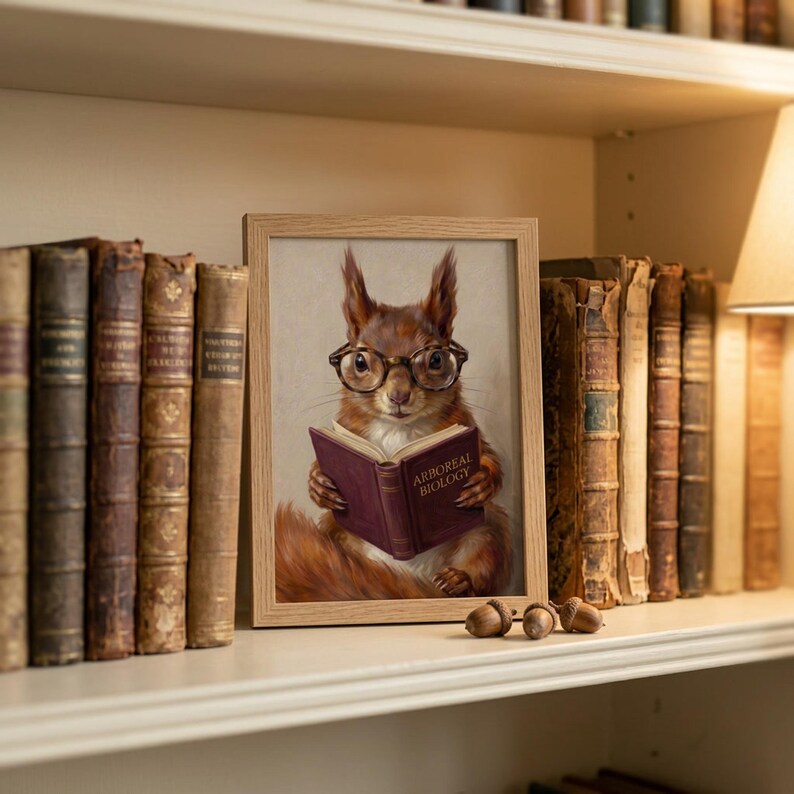 Small oak framed squirrel reading print propped on a bookshelf beside antique leather books and three acorns