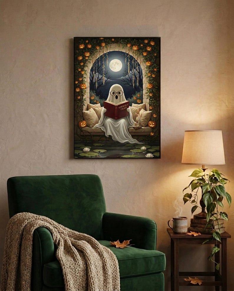 The pumpkin arch ghost reading print framed above a green velvet armchair with a knit throw and a warm lamp