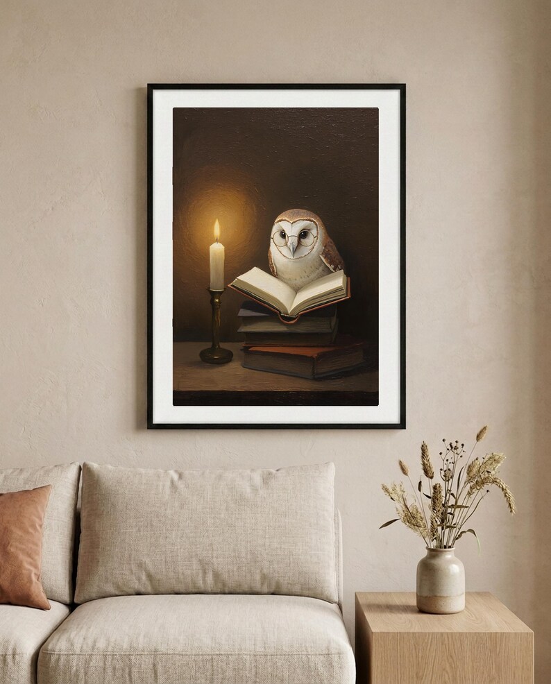 Framed barn owl print reading by candlelight, hung above a linen sofa on a warm neutral wall