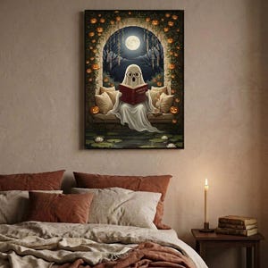 The pumpkin arch ghost reading print framed above a bed with linen bedding and a lit candle on the nightstand