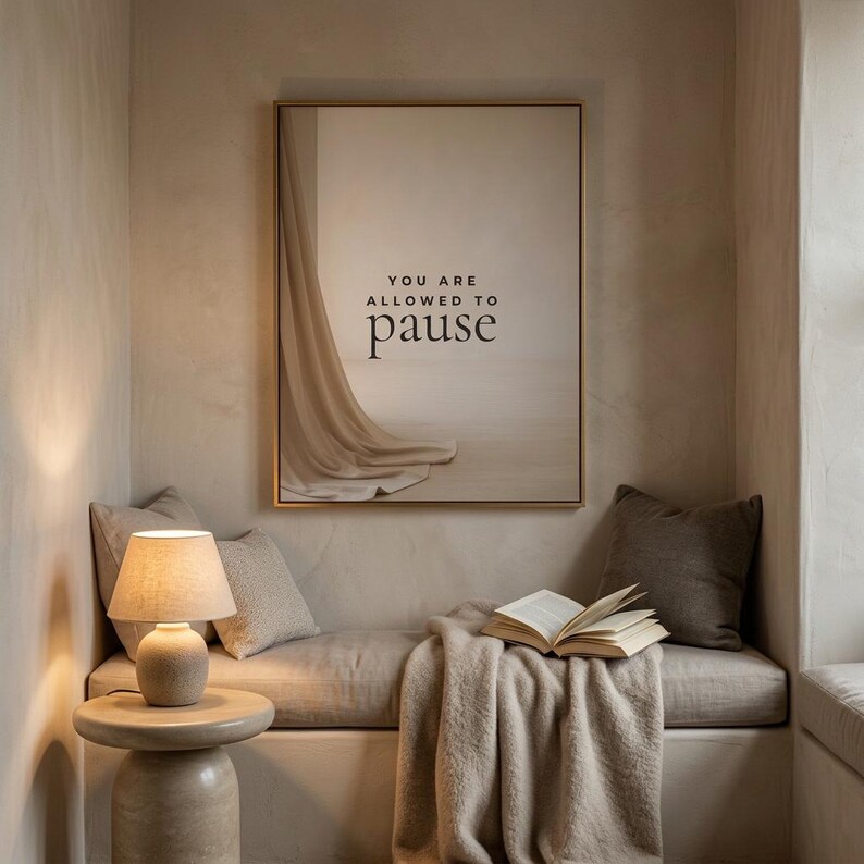 You Are Allowed to Pause styled in a cozy neutral reading corner, hung in a thin gold frame with no mat. neutral printable wall art, minimalist home decor, Japandi style, calm living room decor, slow living digital download.