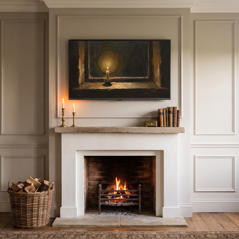 Candle in a frosted window art from the set on a Frame TV above a stone mantel in a panelled living room, with a lit fire, candlesticks, a log basket and an armchair