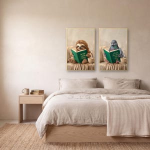 Two prints from the set, the sloth and the pigeon, in gold frames above a bed made up in linen bedding, with a pale oak nightstand alongside