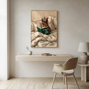 The squirrel reading print framed above a floating desk with a moulded chair, a mug and a ceramic lamp in a bright minimal workspace