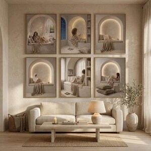 Set of six beige reading nook prints above a cream sofa, with a candle and a ceramic lamp on a low travertine table and olive branches in a tall floor vase.