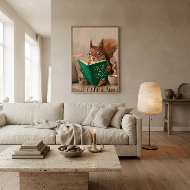 Squirrel reading wall art framed on a warm plaster wall in a calm light-filled living room with a cream linen sofa