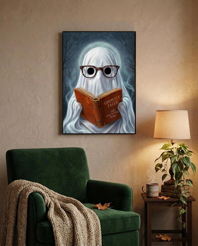 The ghost reading print above a green velvet armchair with a knit throw, a warm lamp and a stack of old books