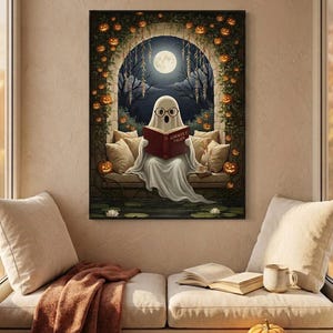 The pumpkin arch ghost reading print framed above a cushioned window bench with a wool throw and a small pumpkin